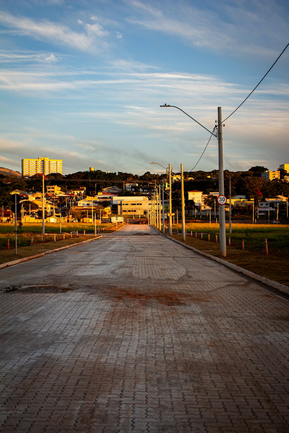 A newly paved residential street leads into a developing neighborhood.